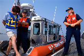 Adult male being arrested by USCG officers for boating under the influence